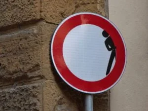 man hiding signage on brick wall