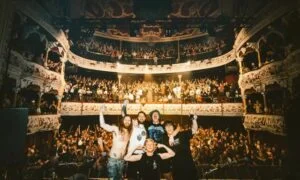 The Scratch posing on stage in front of a packed theatre audience