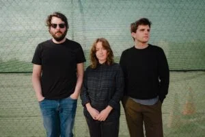 Art Moore, three band members, in front of green netting