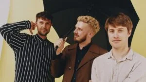 Beatenberg, three band members, under a black umbrella