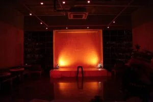 An empty theatre stage lit in warm red light