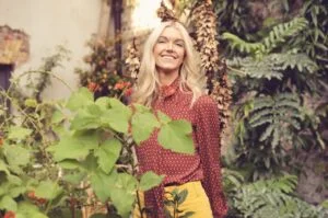 Harriet smiling among green leaves