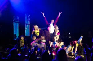 Performers on a purple-lit stage at the House of Suarez Vogue Ball