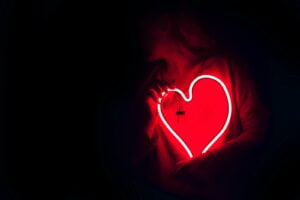 a heart shaped neon sign in the dark