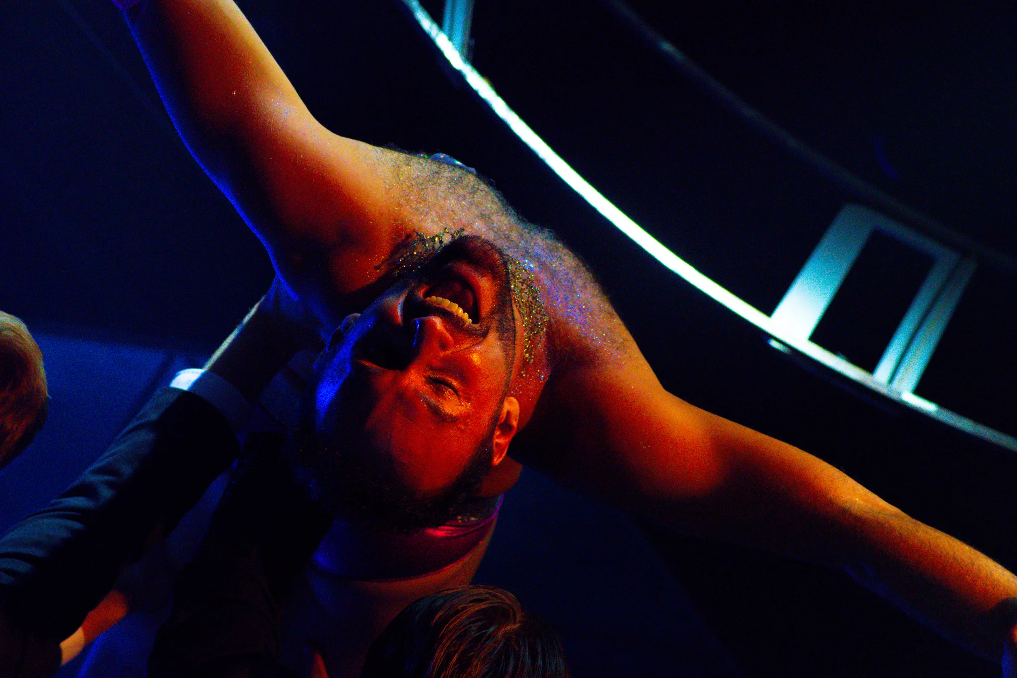 A Vogue Ball performer seen from below under blue light