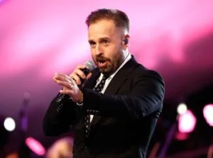 Alfie Boe singing in a dark suit