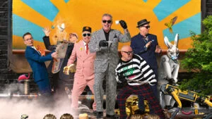 Madness, the band in colourful suits and hats, posing on stage