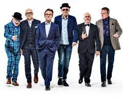 Madness, six band members in suits and hats, walking towards the camera