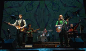 The band performing on stage in Come Together, photo by Andrew AB Photography