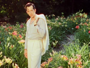 Pokey LaFarge in a cream suit among orange lilies