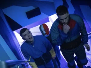 Still from Kneecap: three young men in tracksuits, one wearing a tricolour balaclava