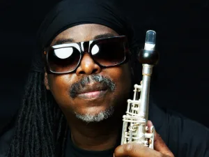 Courtney Pine in sunglasses holding a soprano saxophone