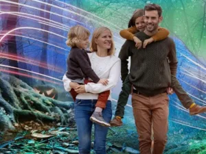 A family with two children walking through a glowing woodland trail