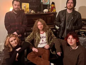 Tepid Days, five band members, in a room with an old piano