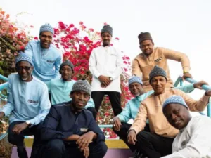 Orchestra Baobab band members posing in front of bougainvillea