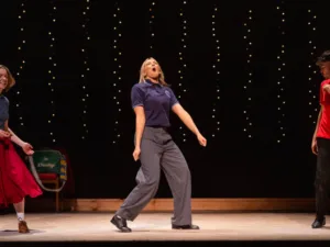 A performer mid-dance on stage in Do I Love You? at Shakespeare North Playhouse