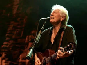 Graham Nash singing and playing acoustic guitar