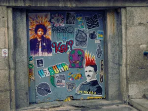 A metal door covered in stickers and street art