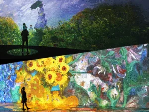 Visitors walk through projections of Monet and Van Gogh paintings at an immersive art show
