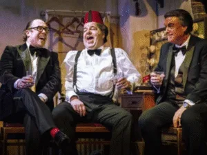 Three actors in dinner suits laughing in The Last Laugh at Liverpool Playhouse