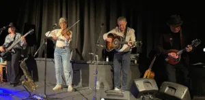 Simply Dylan, four musicians with guitars and fiddle, performing at The Bijou