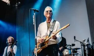 Paul Weller playing guitar on stage at Liverpool Waterfront