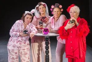 Four actors in pyjamas and hair curlers around a table in Desperate Scousewives